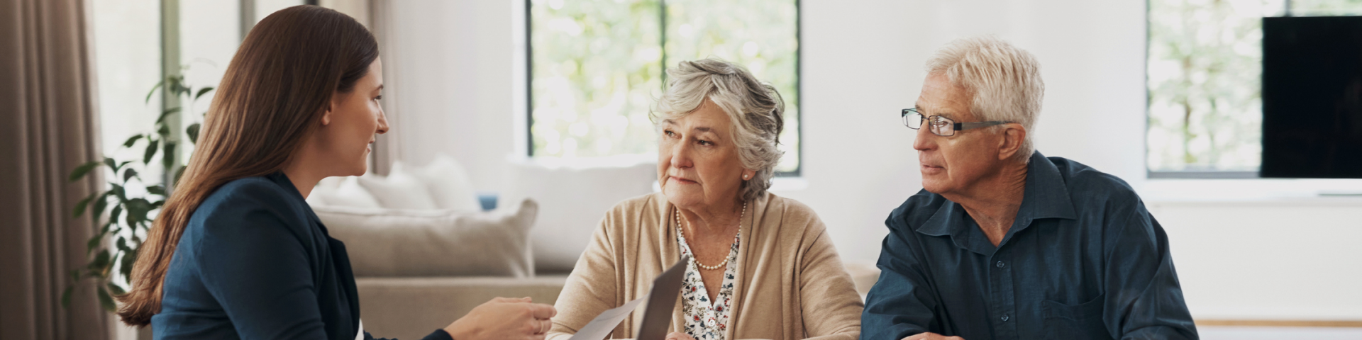 foto van een vrouw van middelbare leeftijd met een koppel van oudere leeftijd aan tafel