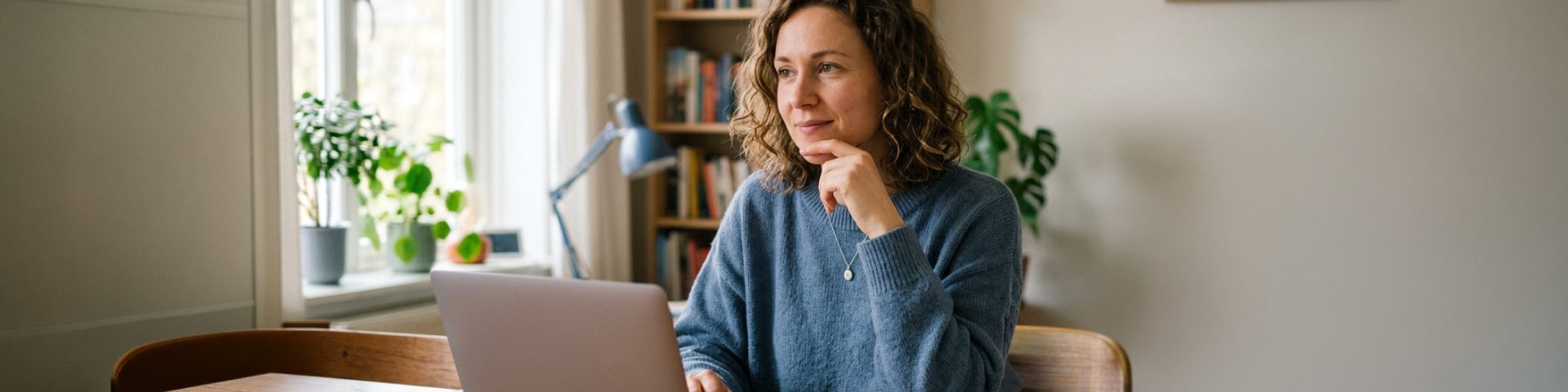 Vrouw achter laptop in thuiskantoor