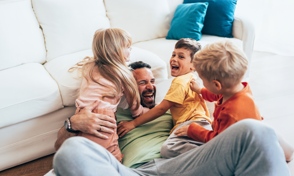 Man speelt met kinderen in woonkamer